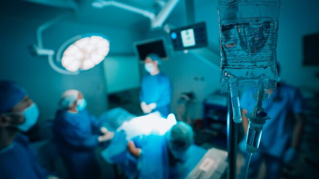 Operatie en medisch onderzoek Medisch onderzoek in operatiekamer met chirurgen en infuus in focus