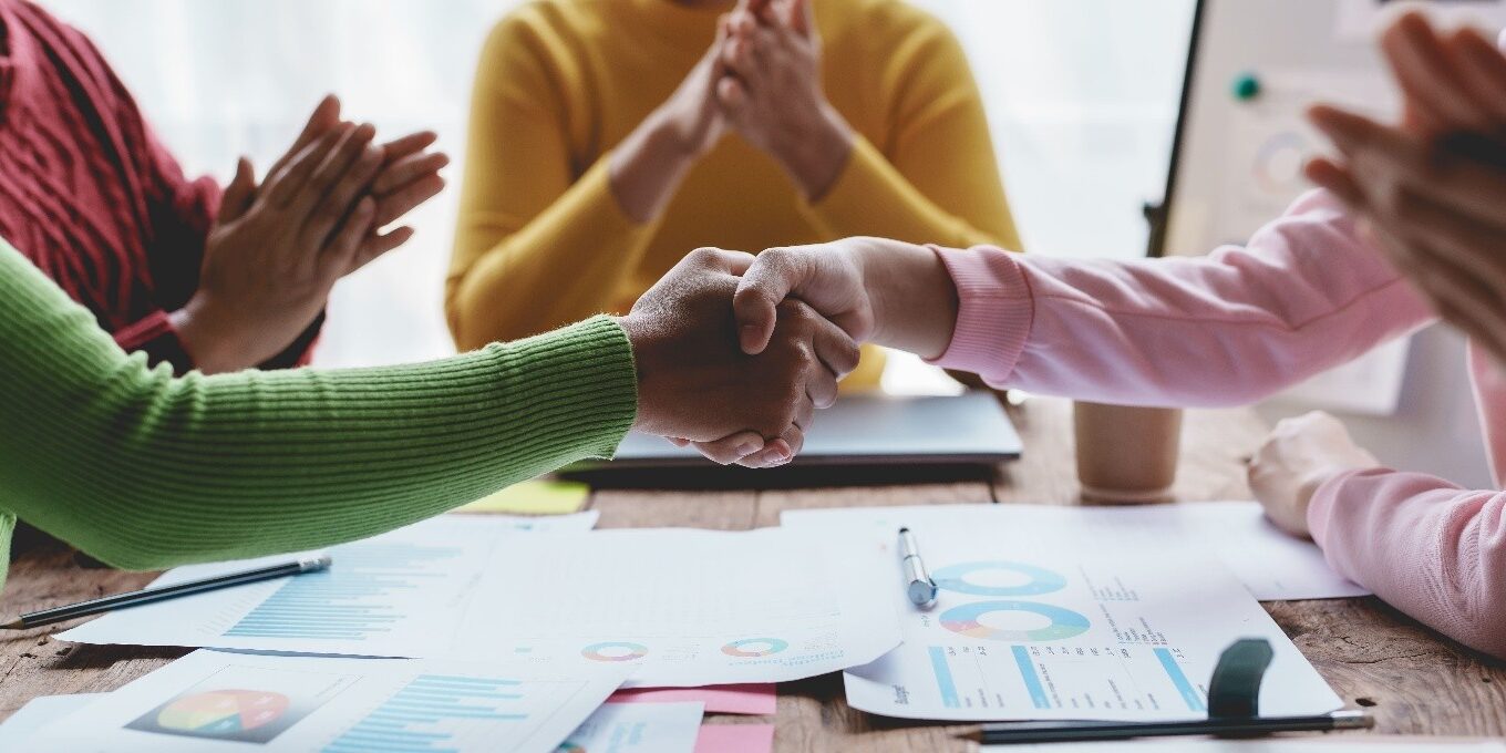 2 mensen schudden de hand en 2 mensen klappen met hun handen