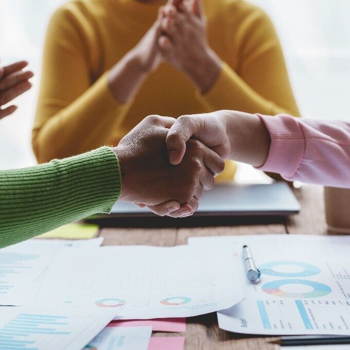 2 mensen schudden de hand en 2 mensen klappen met hun handen