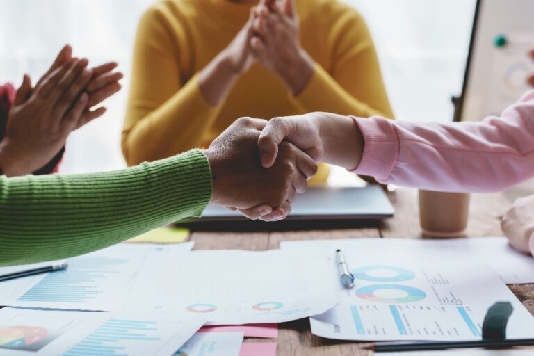 2 mensen schudden de hand en 2 mensen klappen met hun handen